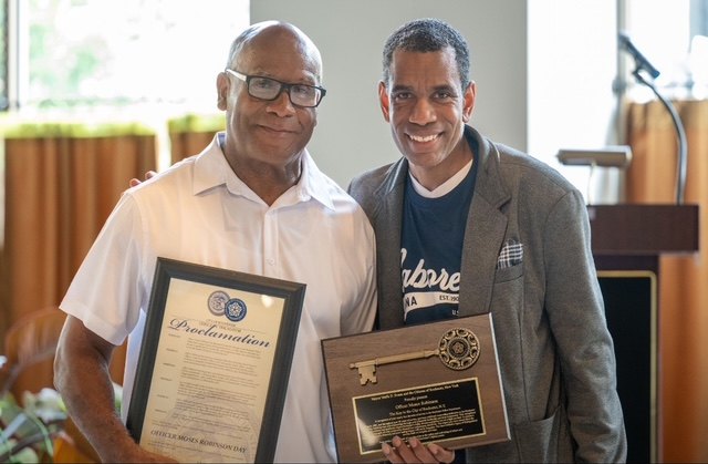 Moses Robinson with Mayor Malik D. Evans, holding the Key to the City and the Officer Moses Robinson Day proclamation